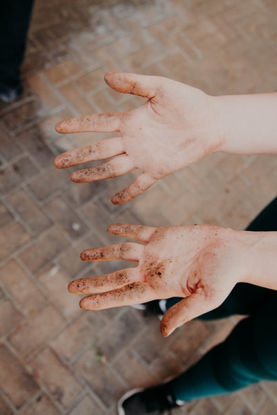 Her hands covered in dirt
